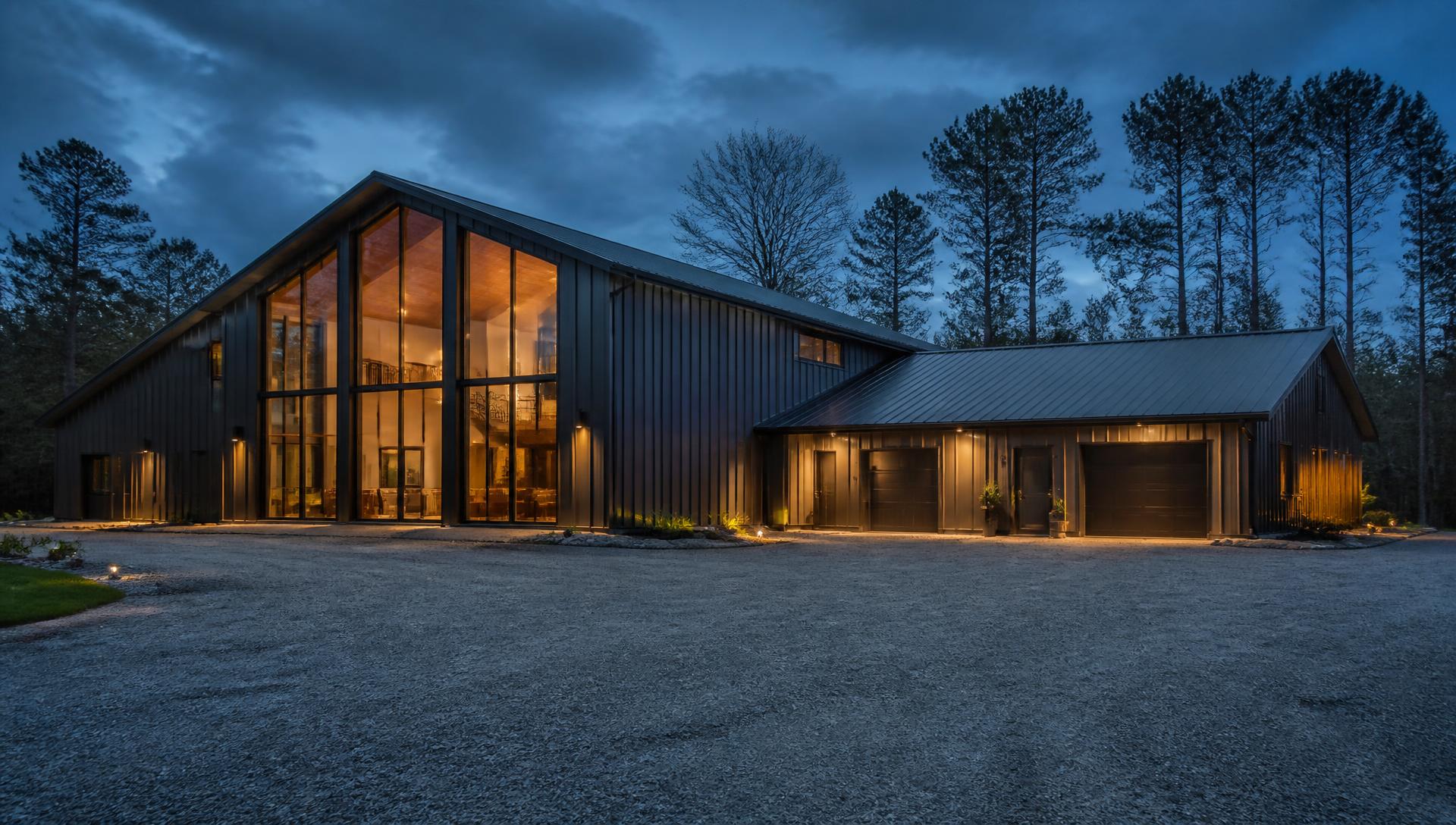Modern dark metal barndominium home at dusk in East Texas